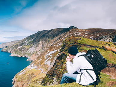 Man sitting on a coastal cliff in Ireland