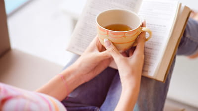 Espace calme - femme lisant un livre avec sa tasse de thé