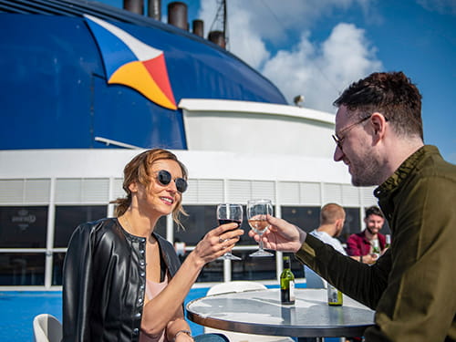 couple enjoying drinks on sun deck of P&O ferry